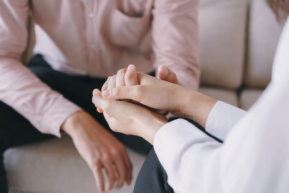 Psychiatrist hands together holding palm of her patient