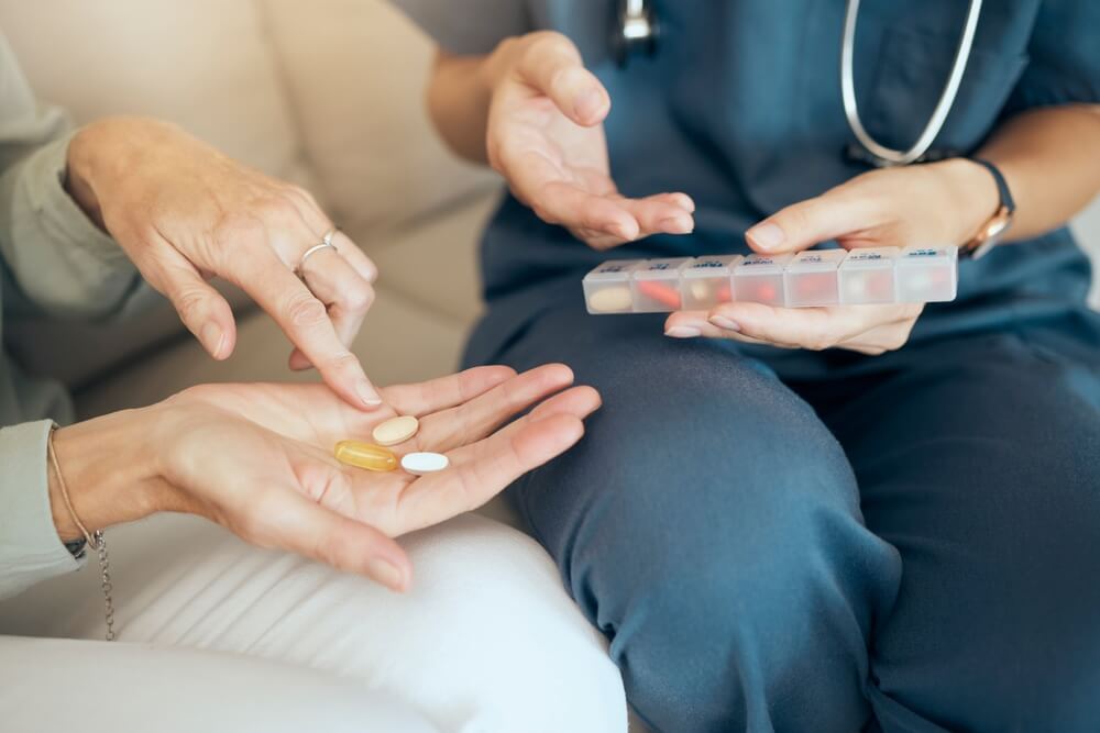 Woman and nurse with pills in house